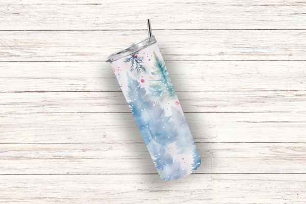 Ein einzelner Thermobecher mit winterlichem Motiv aus blauen Tannenbäumen und roten Akzenten, liegend auf weißem Holzuntergrund.